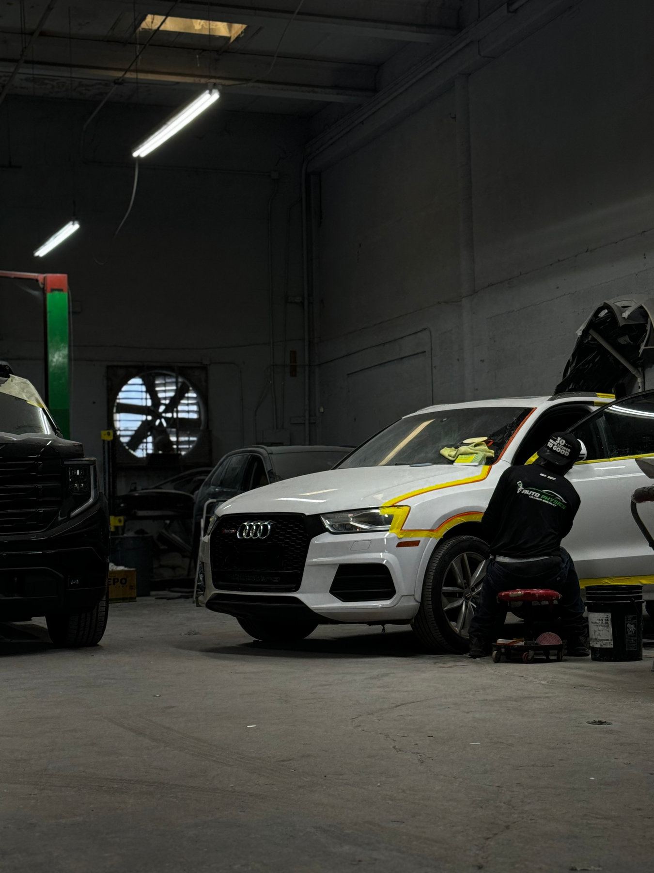 Auto Physics technician masking a vehicle for paint